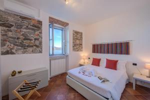 ein Schlafzimmer mit einem weißen Bett und einem Fenster in der Unterkunft Aparthotel Arona - Happy Rentals in Arona