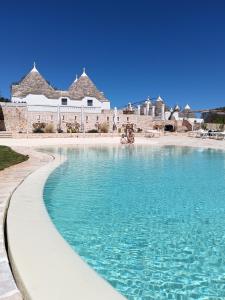 a pool of blue water in front of a building at Borgofreddo Luxury Suite in Monopoli