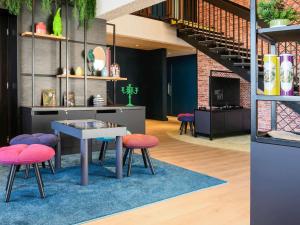 une chambre avec une table, des chaises et un escalier dans l'établissement Novotel Dijon Sud, à Dijon