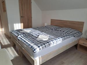 a bedroom with a bed with a checkered blanket at Apartmány Amália in Piešťany