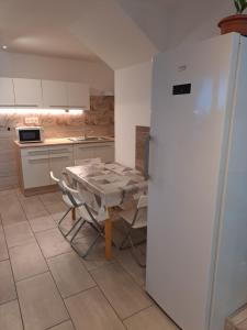 a kitchen with a table and a refrigerator at Apartmány Amália in Piešťany