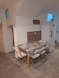 a table and chairs in a kitchen with a refrigerator at Apartmány Amália in Piešťany