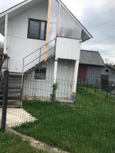 een wit huis met een hek ervoor bij Casa de vacanta Balan in Prundul Bîrgăului