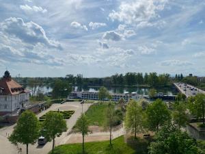 een uitzicht op een park met een gebouw en een meer bij Ferienwohnung Rheinblick in Kehl am Rhein