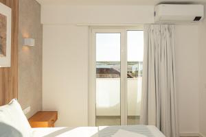 1 dormitorio con cama y ventana grande en Faro Heart Suites, en Faro