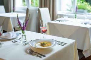 een tafel met een bord eten en een glas wijn bij Hotel Radun in Luhačovice