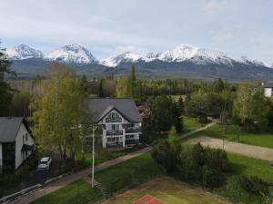 eine Luftansicht eines Hauses mit Bergen im Hintergrund in der Unterkunft Vila Horec - depandance hotela Hubert Vital Resort in Vysoké Tatry