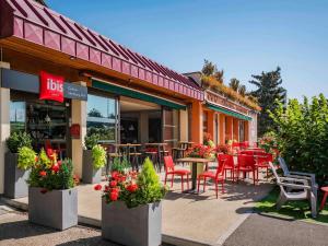 un restaurant avec des tables et des chaises en face de celui-ci dans l'établissement ibis Colmar Est - Hotel Restaurant en Alsace, à Colmar