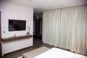 Uma TV ou centro de entretenimento em The White Orchid Hotel