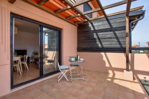 une terrasse avec une porte en verre et une table avec des chaises dans l'établissement Villa Norteventura, à Majanicho