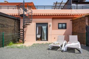 2 chaises et une table en face d'une maison dans l'établissement Villa Norteventura, à Majanicho