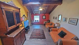 a living room with orange couches and a tv at Locanda Le Panche in Pistoia