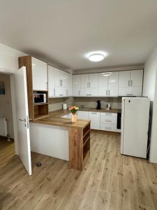 a kitchen with white cabinets and a white refrigerator at Apartment Athens in Sombor