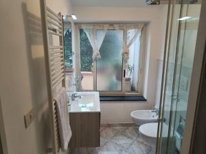 a bathroom with a sink and a toilet and a window at Il Girasole in Gaeta