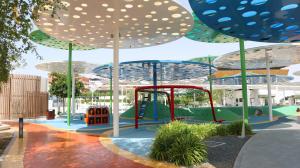 um parque infantil com guarda-sóis num parque em Valentina Studio Transit Apartment in Masdar City em Abu Dhabi