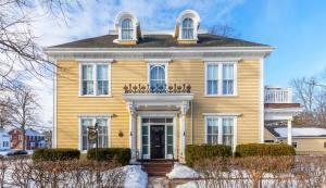 una casa gialla con porta d'ingresso e finestre di Fitzroy Hall a Charlottetown