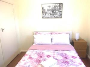 ein Schlafzimmer mit einem Bett mit einer rosa Decke in der Unterkunft Ideal accommodation in Glen Waverley in Glen Waverley