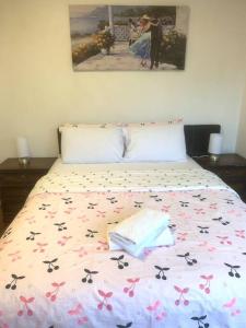 ein Bett mit einer Decke mit Blumen drauf in der Unterkunft Ideal accommodation in Glen Waverley in Glen Waverley