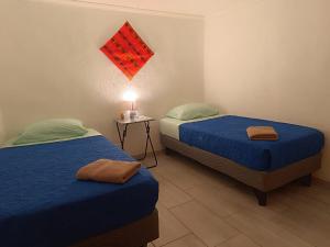 - une chambre avec deux lits et une table avec une lampe dans l'établissement Misky Wasi, à San Pedro de Atacama