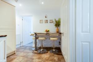 una cucina con tavolo e due sgabelli di Little Nook Apartment a St Ives