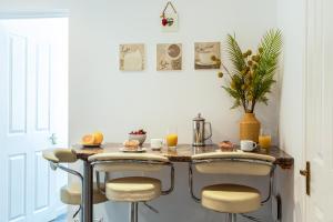 una cucina con tavolo, sedie e succo d'arancia di Little Nook Apartment a St Ives