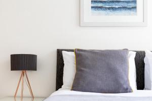 una camera da letto con un letto con un cuscino e una lampada di Little Nook Apartment a St Ives