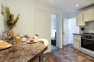 una cucina con bancone e tavolo con frutta di Little Nook Apartment a St Ives