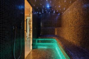 uma piscina numa casa de banho com iluminação verde em Góralska Strefa & SPA em Kościelisko