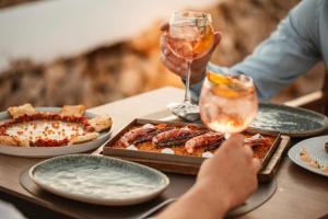 uma mesa com pratos de comida e um copo de vinho em Lago Resort Menorca - Suites del Lago Adults Only em Cala'n Bosch