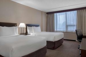 Tempat tidur dalam kamar di Ramada Plaza by Wyndham Calgary Downtown