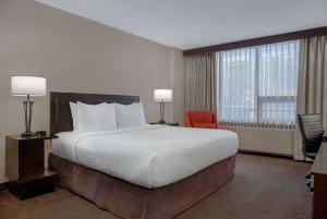 Tempat tidur dalam kamar di Ramada Plaza by Wyndham Calgary Downtown