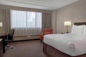 Tempat tidur dalam kamar di Ramada Plaza by Wyndham Calgary Downtown