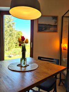 a vase of flowers sitting on a wooden table at Ferienwohnung Peetsch am See in Mirow