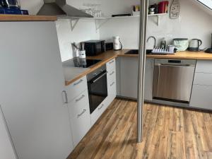 una cucina con armadietti bianchi e pavimenti in legno di Ferienwohnung Niederrotweil a Niederrotweil