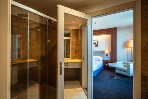 a bathroom with a shower and a bedroom at Delta Hotels by Marriott Olbia Sardinia in Olbia