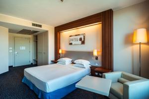 a hotel room with a bed and a chair at Delta Hotels by Marriott Olbia Sardinia in Olbia