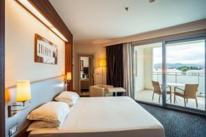 a hotel room with a bed and a balcony at Delta Hotels by Marriott Olbia Sardinia in Olbia