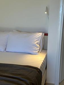 Una cama con una almohada blanca encima en Papanestoras Apartments, en Kardhamili