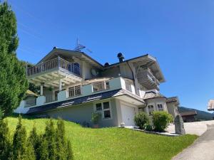 uma grande casa branca com varandas numa colina em Apartment Kerer em Wald im Pinzgau