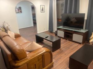 a living room with a couch and a flat screen tv at Newly Renovated House near Melbourne Airport in Melbourne