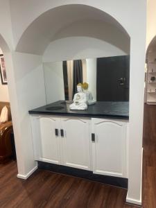 a kitchen with white cabinets and a black counter top at Newly Renovated House near Melbourne Airport in Melbourne