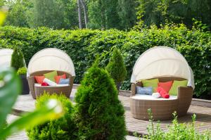 2 sedie in vimini con cuscini colorati in giardino di Das Frühstückshotel Sankt Peter-Ording a Sankt Peter-Ording