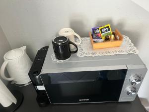 - un four micro-ondes avec une tasse de café dans l'établissement Šiauliu apartamentai, à Šiauliai