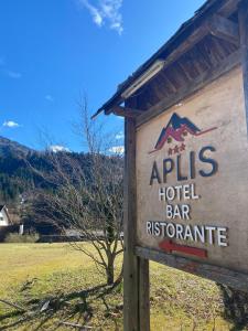 un cartello per un bar ristorante in un campo di Hotel Aplis a Ovaro