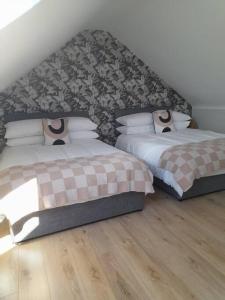 een slaapkamer met 2 bedden en een muur bij PatsView Lodge in Donegal