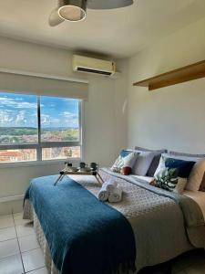 een slaapkamer met een bed en een groot raam bij Studio 1131 - Extraordinário in Ribeirão Preto