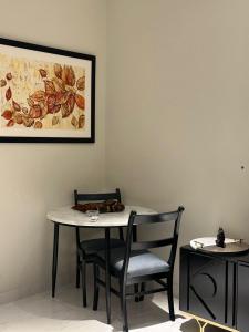 a table and chairs in a room with a picture on the wall at The Opus Luxury Residences in Lahore