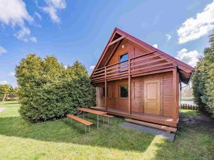 eine kleine Holzhütte mit einer Bank im Gras in der Unterkunft Pensjonat Kwiatkowski domek nr 3 in Nowęcin