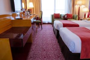 A bed or beds in a room at Dubai Grand Hotel by Fortune, Dubai Airport