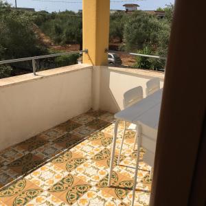 a balcony with a table and chairs on a floor at IL MIO PARADISO in Porto Cesareo